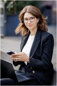 Businessportrait einer Frau mit Handy und Notebook