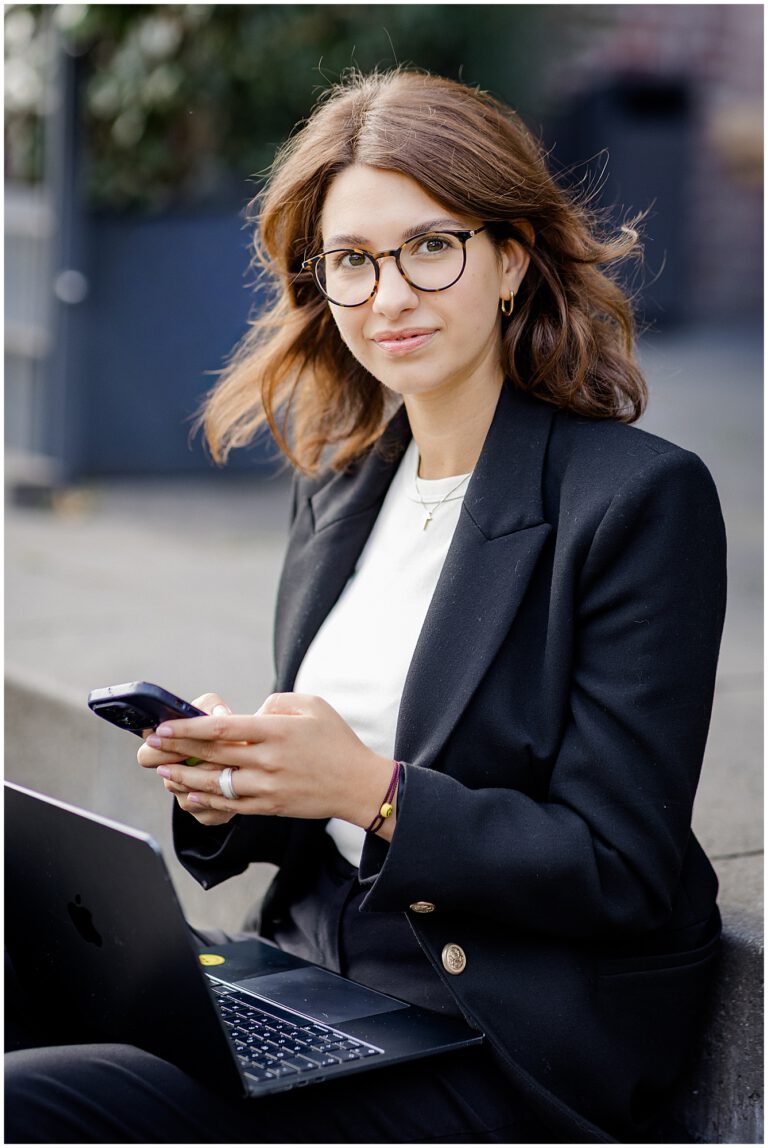 Businessportrait einer Frau mit Handy und Notebook