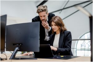Chef und Mitarbeiterin schauen sich auf ihrem Laptop Dinge an