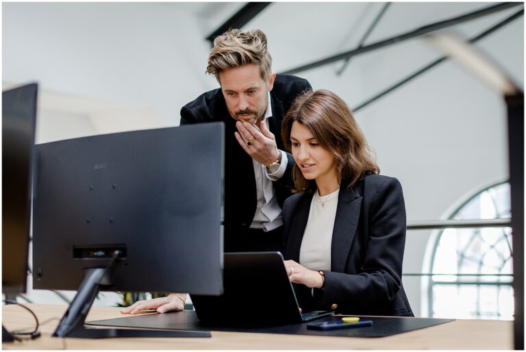 Chef und Mitarbeiterin schauen sich auf ihrem Laptop Dinge an