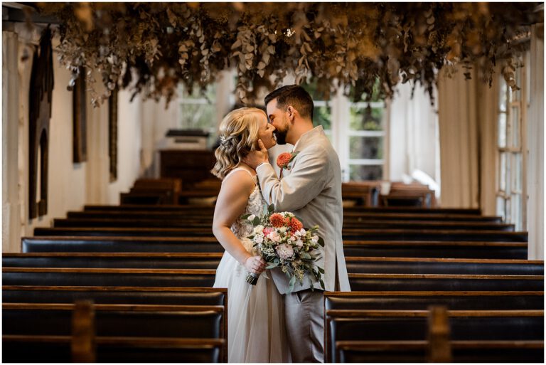Brautpaar steht in der Kapelle im La Dü und küsst sich