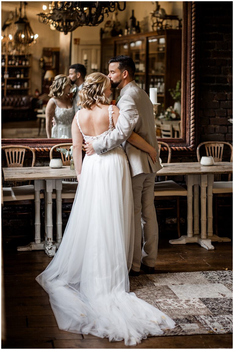 Brautpaar auf ihrer Hochzeit im La Dü steht vor einem groben Spiegel in einer innigen Pose
