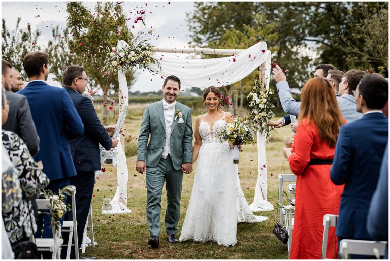 Glückliches Brautpaar beim Auszug ihrer freien Trauung auf dem Neimeshof